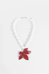 Collar corto con cuentas ovales blancas de acrílico y un gran dije colgante en forma de flor roja.