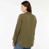 Camisa color verde militar, de corte holgado y manga larga, con cuello camisero y cierre frontal con botones.