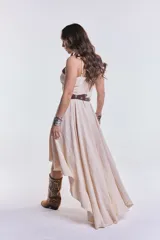 Vestido midi color beige de breteles finos, corte asimétrico y falda con volados.