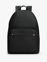 Mochila urbana Tommy Hilfiger de diseño minimalista en color negro. Presenta un compartimento principal amplio con cierre, un bolsillo frontal con cierre y detalle de franja tricolor distintiva de la marca. Incluye asa superior, correas ajustables acolchadas y logo metálico grabado en la parte superior.