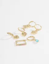 Set de seis aros tipo argolla dorados con dijes colgantes variados: un corazón con ojo turco, una mariposa, un trébol de cuatro hojas con piedras de colores, una flor, un rectángulo con piedras y una gota de cristal turquesa.