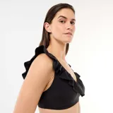 Top de bikini negro de microfibra suave, con escote redondo y volantes decorativos en los tirantes y el frente.