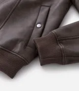 Campera de poliuretano con acabado lavado, diseño de corte regular, cuello camisero, cierre frontal, puños y cintura con rib elástico.