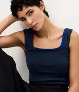 Blusa básica sin mangas de la marca Cortelle, confeccionada en poliamida con elastano. Presenta breteles medianos y escote cuadrado tanto en el frente como en la espalda.