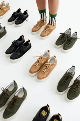 Zapatillas de cuero color marrón, con cordones y suela blanca.