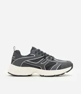 Championes estilo dad sneaker de color gris oscuro, con detalles en blanco y líneas plateadas reflectivas. Combinan malla y paneles sintéticos con una suela voluminosa blanca y negra.