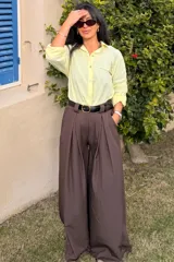 Pantalón de vestir color marrón chocolate, de corte ancho y tiro alto, con pinzas frontales y cinto negro con hebilla dorada incluido.