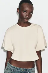 Top crop de algodón con efecto lavado, cuello redondo y mangas cortas holgadas de tipo capa.