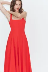Vestido midi de popelín confeccionado en algodón, color marrón, con escote cuadrado, tirantes anchos y diseño acampanado con paneles godets. Cuenta con cierre lateral de cremallera oculta.