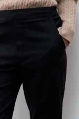 Pantalón de corte recto en color negro, con cierre frontal y bolsillos laterales. Diseño clásico y versátil.
