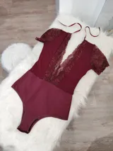 Body de lycra color borgoña con encaje floral en escote y mangas cortas. Breteles finos ajustables.