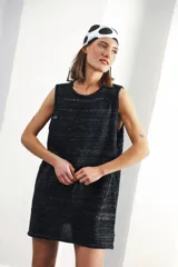 Vestido corto sin mangas, de tejido de punto en color azul marino con efecto jaspeado o tweed en tonos claros. Presenta un corte amplio y relajado, con cuello redondo y bordes en contraste.