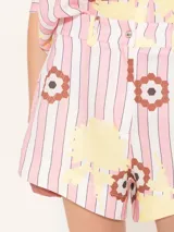 Short de lino con estampado de rayas verticales rosas y blancas, con flores amarillas y marrones.