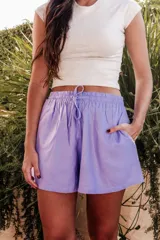 Short de lino color lila con pretina elastizada, cordones regulables y bolsillos delanteros.