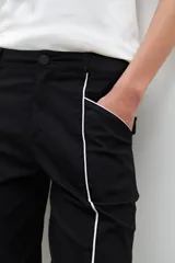 Pantalón negro de corte recto con vivo blanco en los laterales.