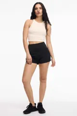 Top deportivo color crema, con espalda baja y copas removibles.