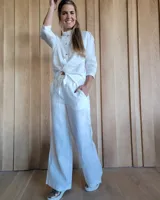 Pantalón de lino blanco, de corte recto y holgado, con cintura elástica y cordón ajustable.