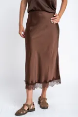 Falda midi negra de acabado satinado, corte al bies, con detalle de encaje en el ruedo.