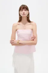 Top strapless de poliéster color rosado, con diseño holgado y elástico superior.