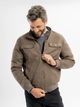 Campera de estilo casual confeccionada en tejido suave con textura tipo gamuza. Presenta cuello alto, cierre frontal, bolsillos laterales y bolsillos frontales con solapa. Incluye detalles de costuras en las mangas y terminaciones elastizadas en puños y cintura.