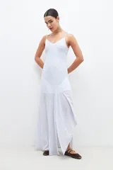 Maxi vestido celeste con rayas verticales blancas y plateadas, breteles finos y corte al bies.