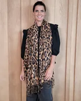 Bufanda de gran tamaño con diseño de estampado animal print de leopardo y terminaciones con flecos en los extremos.