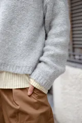 Buzo tejido en mohair de corte crop, con cuello redondo y tajos laterales. Diseño holgado con mangas largas.