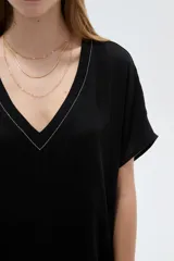 Blusa blanca de poliéster de corte holgado, con escote en V y mangas cortas.