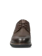 Zapato casual Hush Puppies modelo Bolo, confeccionado en cuero color marrón oscuro. Presenta cierre con cordones, suela de EVA flexible y diseño estilizado con costuras visibles en el borde de la suela.