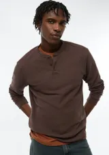 Camiseta Henley de manga larga color marrón, con textura waffle y tapeta de tres botones en el cuello.