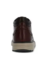 Botín de cuero color marrón oscuro con diseño de caña media, cierre mediante cordones y suela de EVA en tono beige con base de goma.