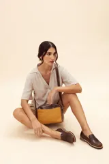 Mocasín de cuero vacuno en color marrón, con diseño bitono que combina texturas lisas y con grabado tipo cocodrilo en el empeine. Cuenta con detalle de estribo clásico y suela plana con vira en contraste.