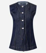 Chaleco largo de jean azul oscuro, con corte acinturado, cierre frontal abotonado y costuras con pespuntes en contraste. Presenta un diseño sin mangas con cuello redondo.