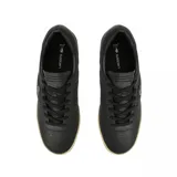Championes Lacoste modelo Aura, de cuero negro con textura granulada, cordones al tono y suela de goma en color beige. Presenta el logo del cocodrilo metálico en el lateral.