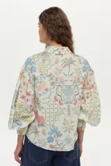Camisa de lino y viscosa color crudo con estampado multicolor, cuello camisero, cierre frontal con botones y mangas largas abullonadas.