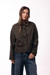 Campera corta color marrón, con cuello alto estructurado, cierre frontal y bolsillos delanteros con solapa. Presenta puños y cuello en tejido acanalado, con un diseño de corte recto y minimalista.