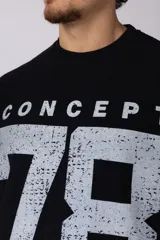 Remerón de corte oversize con cuello redondo y mangas cortas. Presenta un diseño estampado frontal con la palabra 'CONCEPT' y el número '78' en efecto desgastado, además de dos franjas horizontales en las mangas.