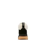 Bota de estilo montañista color negro, confeccionada en piel impermeable con forro de corderito sintético en el cuello. Presenta cordones con ganchos metálicos, tirador en el talón y una suela de plataforma dentada en color tostado.