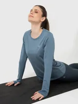 Remera de manga larga con cuello redondo y calce ajustado, confeccionada en tejido técnico con tecnología Aircool de secado rápido. Presenta orificios para el pulgar en los puños y un pequeño logo bordado en el pecho.