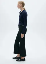 Pantalon de vestir negro de corte recto y tiro medio, con bolsillos laterales y cierre oculto de botón, gancho y cremallera.