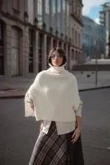Poncho tejido de lana con cuello alto y diseño de calce relajado, ideal para capas de abrigo.