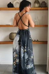 Vestido largo de seda con estampado abstracto en tonos marrones, beige y destellos dorados, con escote en V profundo, tirantes de cuerda anudados al cuello y la cintura, y tajo lateral en la falda.