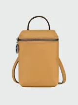 Cartera tipo estuche o vanity bag de cuero color mostaza, con forma rectangular vertical. Presenta un asa superior corta y tiras ajustables para llevar al hombro o cruzada. Cierre superior con cremallera negra y logo de caballo al galope grabado en el centro.