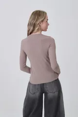 Remera de manga larga ajustada al cuerpo, color blanco, con cuello redondo bajo y tejido acanalado.