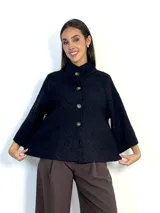 Chaqueta tipo capa de lana bouclé en color marrón, con cuello mao y cierre frontal de botones grandes. Presenta mangas tres cuartos con puños ajustados de tejido acanalado.