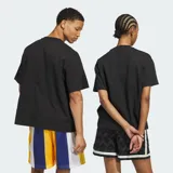 Remera negra de algodón con ajuste holgado, cuello redondo y mangas cortas. Presenta un estampado gráfico frontal con la palabra "ADIDAS" en estilo universitario con borde amarillo y azul, acompañado de un emblema circular en el centro.