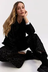 Campera de corte clásico con cuello camisero y cierre frontal de botones, confeccionada en tejido de algodón con textura en relieve de animal print.