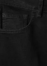 Jeans de terciopelo color negro, tiro alto y estilo flare, con diseño de cinco bolsillos y trabillas para cinturón.