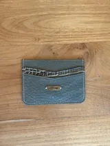 Tarjetero de cuero color verde con detalle de cuero con textura de cocodrilo en la parte superior y costuras a contratono.