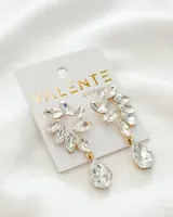 Aros colgantes con forma de hojas y gota, con engarce dorado y cristales transparentes.